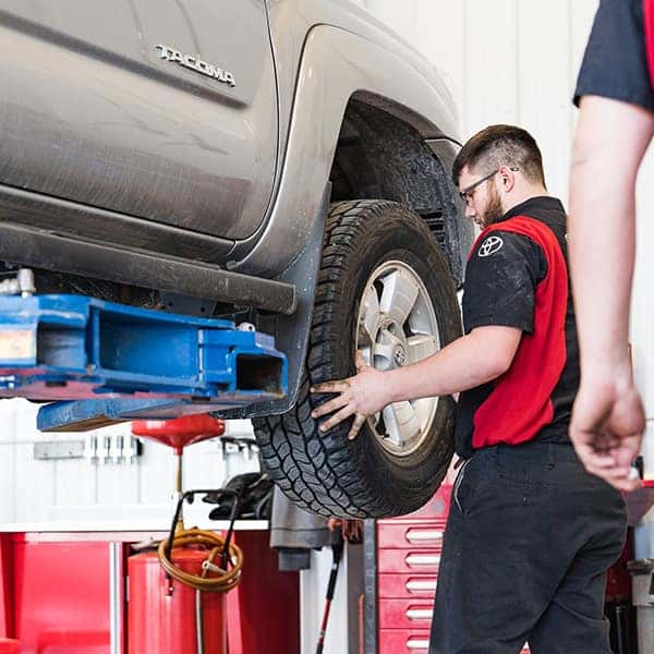 a toyota certified technician performing a tire rotation at anderson weber toyota