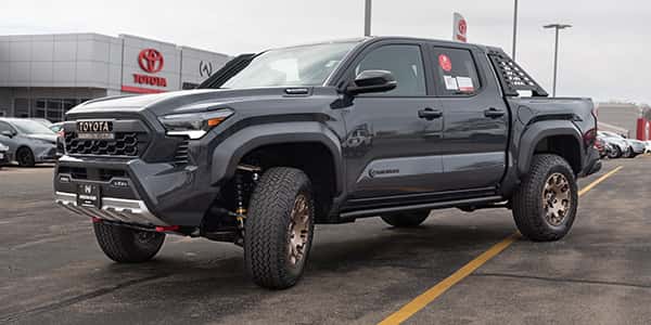 a brand new toyota tacoma trailhunter in front of anderson weber toyota in dubuque iowa