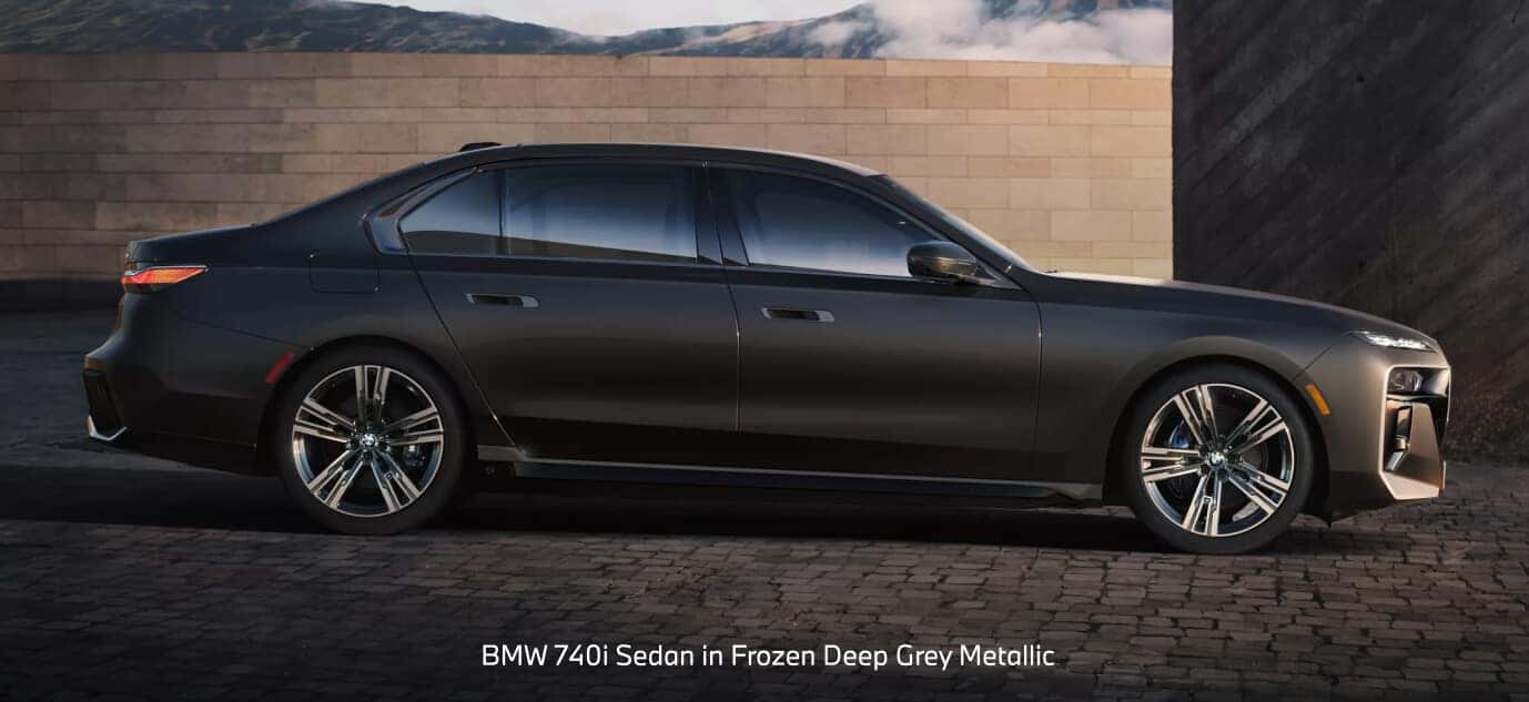 BMW 740i Sedan exterior in Frozen Deep Grey Metallic on a volcanic mountain highway.