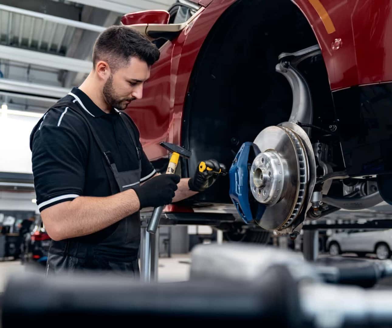 A BMW certified service technician removes retaining pins on a BMW vehicle’s brake calipers