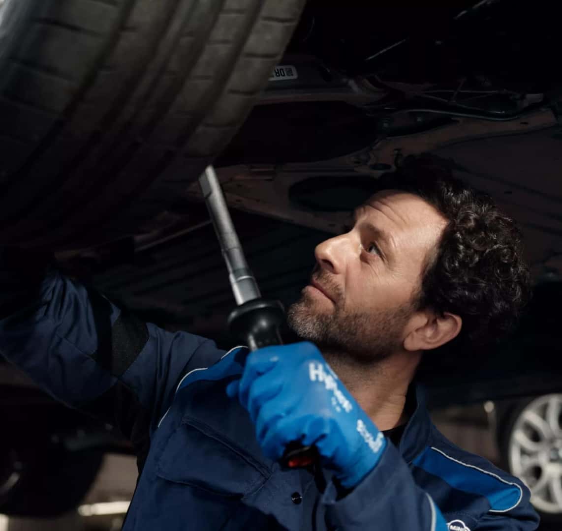 A BMW certified service technician adjusts a BMW vehicle’s wheel alignment