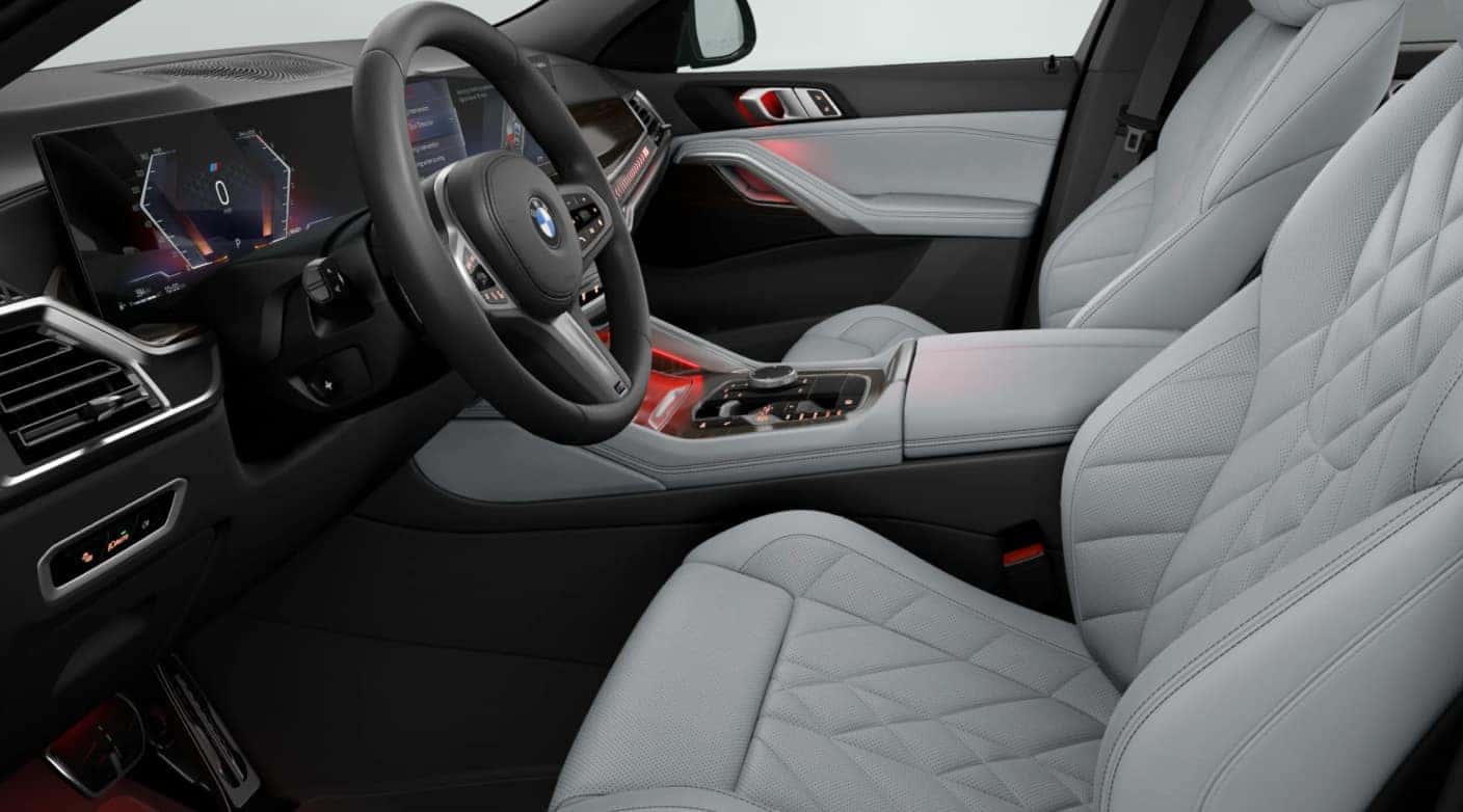 2027 BMW X6 interior featuring a sleek steering wheel, digital dashboard, quilted leather seats, and ambient lighting.