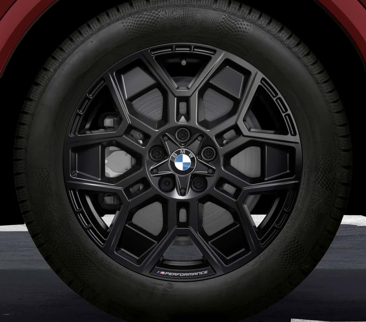 Close-up view of a matte black BMW M Performance light alloy wheel featuring a center cap and brake caliper.