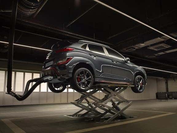 a hyundai kona on a car lift in a garage