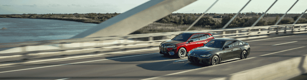 2022 BMW i4 and BMW iX driving over a bridge