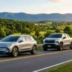 A silver Chevrolet Equinox EV and Silverado EV driving on a scenic winding road through green hills.