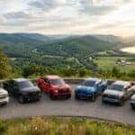 Six Chevy pickup trucks lined up on a scenic mountain overlook with a winding river valley in the background. (Representative image for illustration purposes only. Actual vehicle may vary based on trim and configuration.)