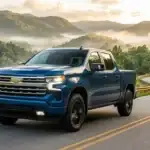 A blue Chevrolet Silverado pickup truck driving along a winding mountain road at sunrise. (Representative image for illustration purposes only. Actual vehicle may vary based on trim and configuration.)