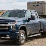 A black Chevrolet Silverado 1500 and a white Silverado 2500 HD parked side-by-side in a dealership lot. (Representative image for illustration purposes only. Actual vehicle may vary based on trim and configuration.)
