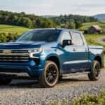 Blue Chevrolet Silverado crew cab pickup truck parked on a winding gravel road in a rolling green countryside. (Representative image for illustration purposes only. Actual vehicle may vary based on trim and configuration.)