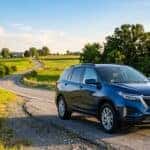 Blue Chevrolet Equinox parked along a winding rural road passing through green rolling hills. (Representative image for illustration purposes only. Actual vehicle may vary based on trim and configuration.)