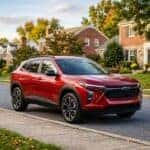 Red Chevrolet crossover SUV parked on a curb in a suburban neighborhood during autumn. (Representative image for illustration purposes only. Actual vehicle may vary based on trim and configuration.)