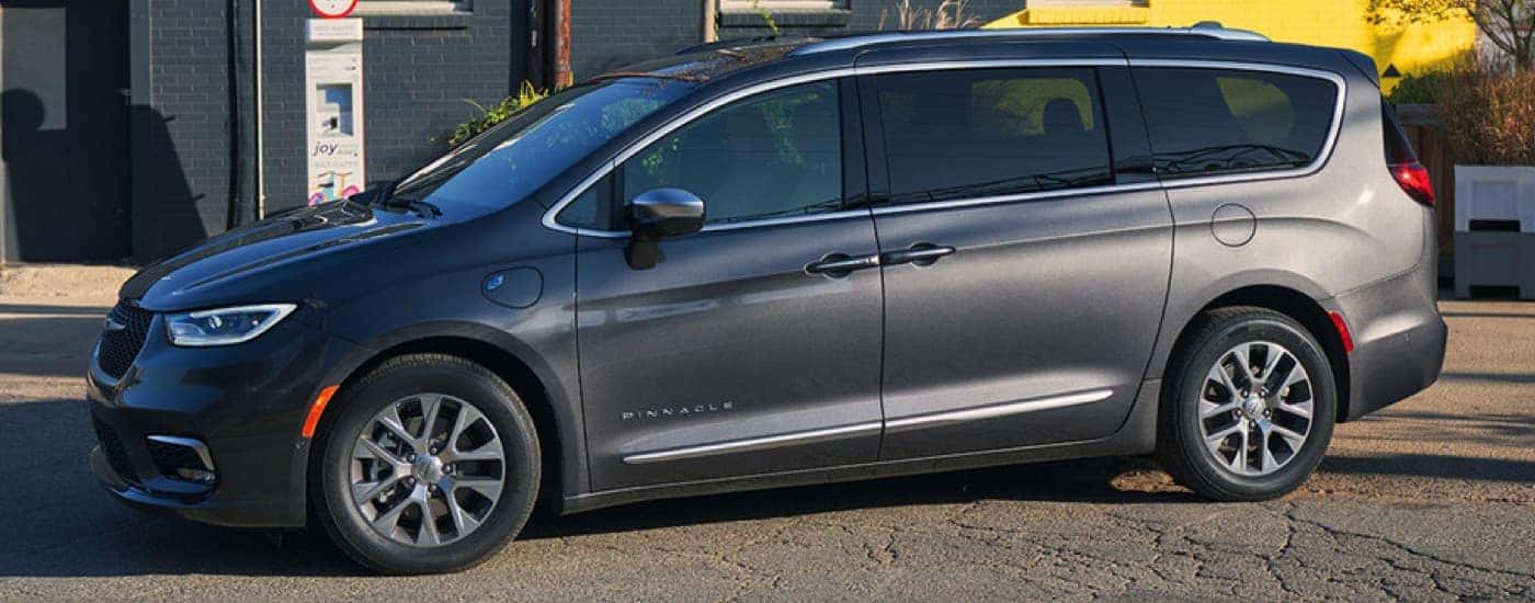 A grey 2022 Chrysler Pacifica is shown from the side parked in an empty lot. 