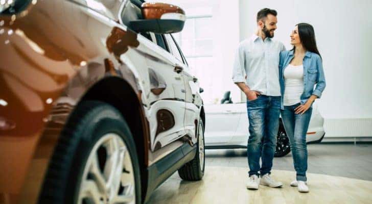 A couple is shown at a certified pre-owned vehicle dealer.