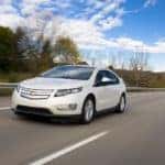 A white 2014 Chevy Volt is shown driving on a highway.