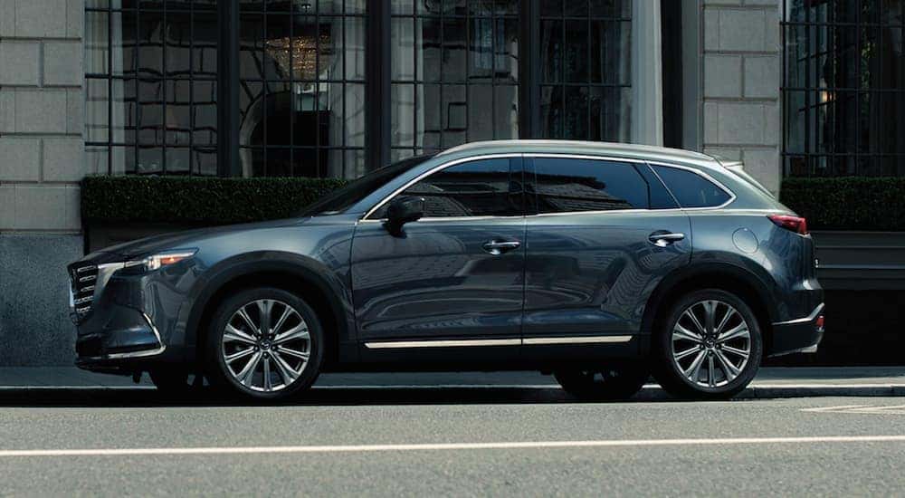 A blue 2021 Mazda CX-9 is shown parked on a city street.