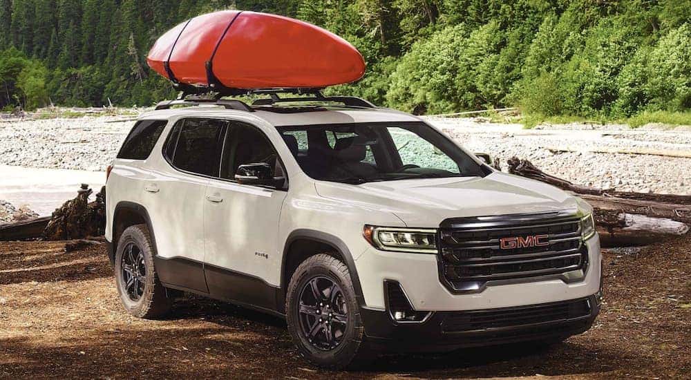 A white 2022 GMC Acadia is shown parked off-road.