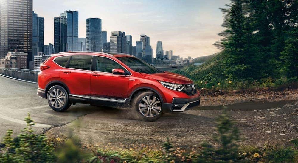 A red 2020 Honda CR-V is shown driving from a city.