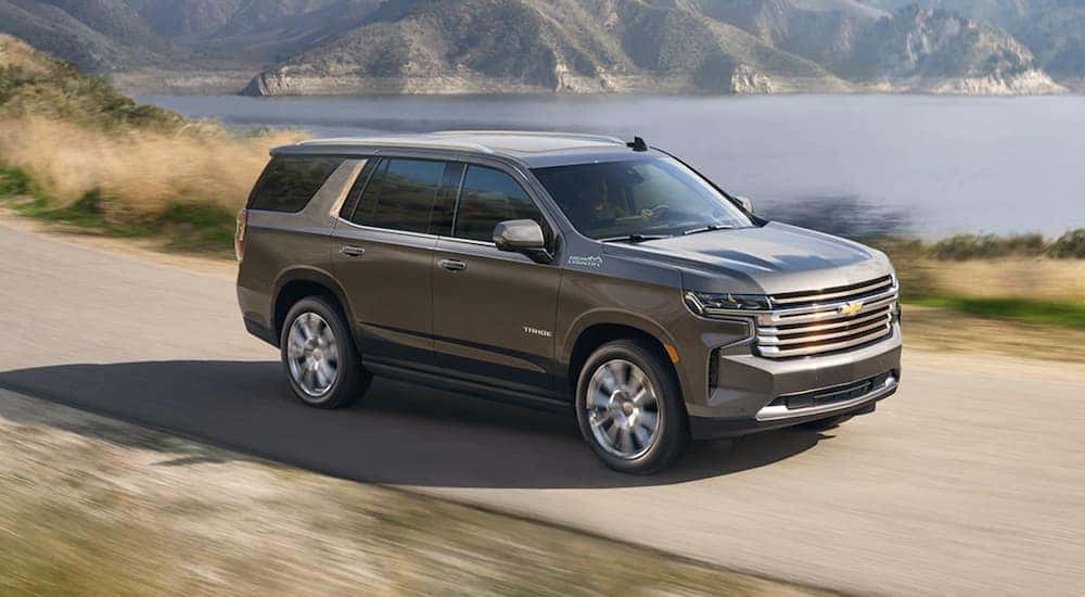 A gray 2020 Chevy Tahoe is shown driving near a lake.