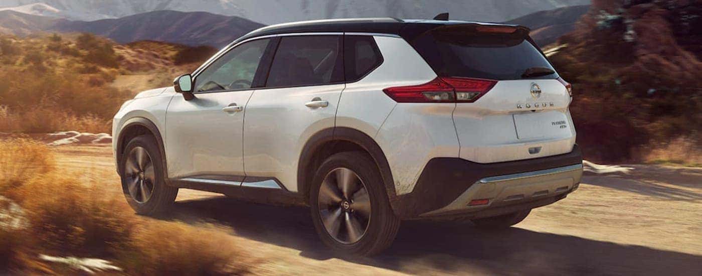 A white 2021 Nissan Rogue driving on a sandy trail.