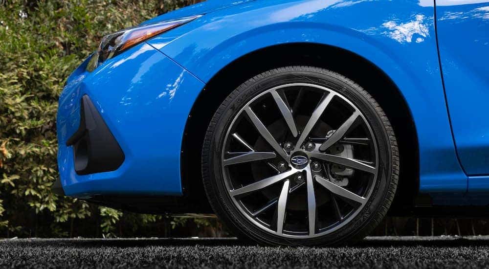 A close-up on the wheel rim of a blue 2024 Subaru Impreza.