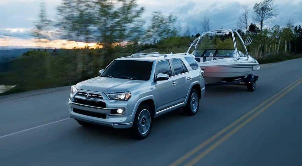 A silver 2023 Toyota 4Runner Limited towing a boat.