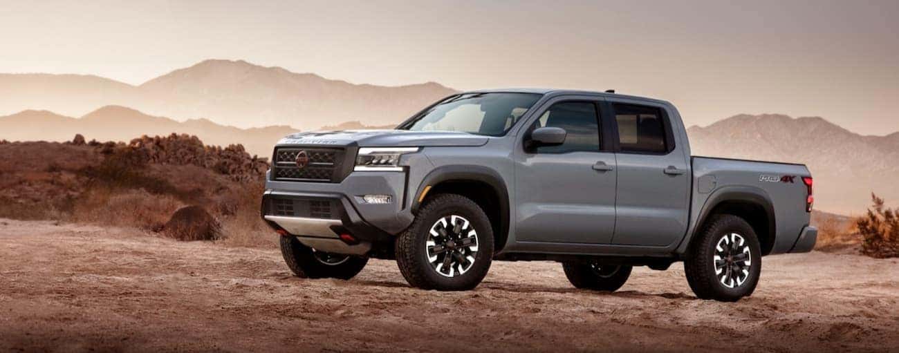 A grey 2022 Nissan Frontier parked off-road and angled left.
