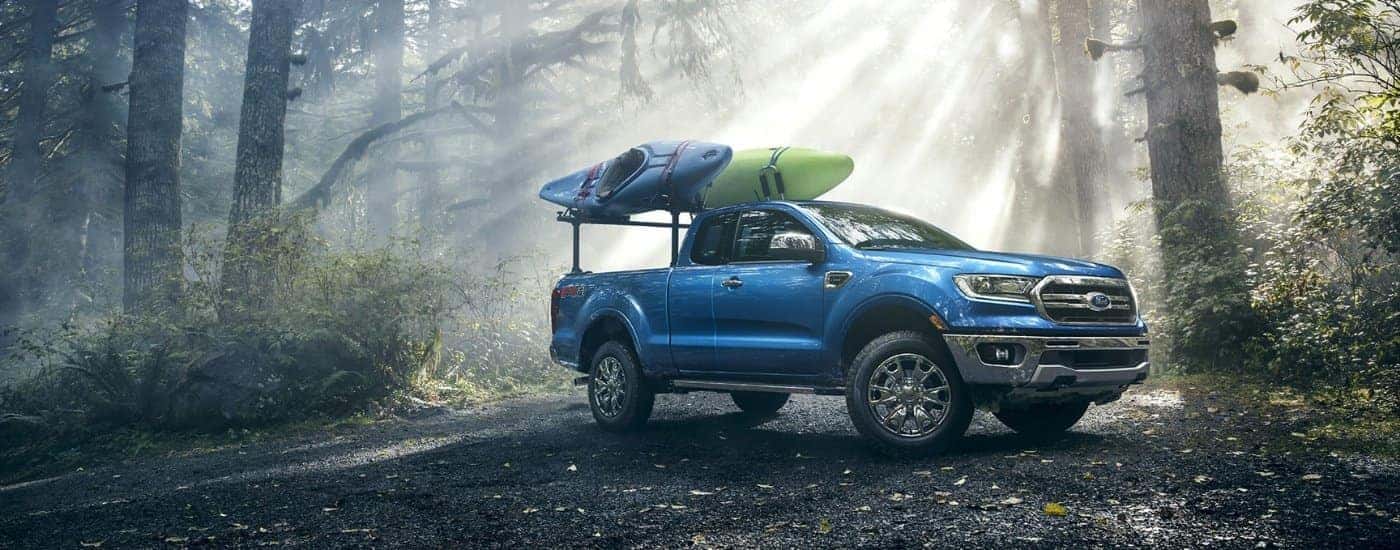 A blue 2021 Ford Ranger FX4 is shown parked on a clearing in the woods.