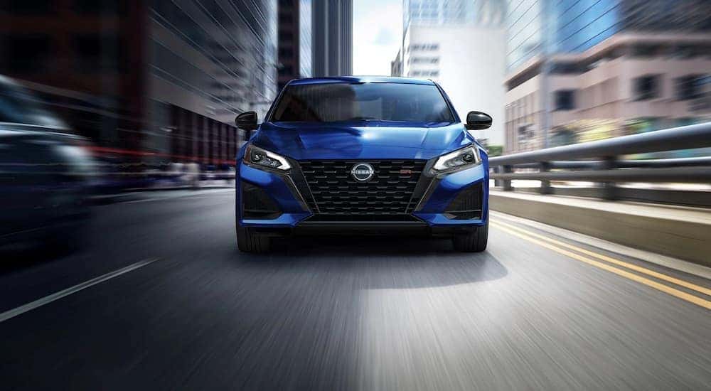 A blue 2023 Nissan Altima SR is shown from the front after leaving a used car dealership.