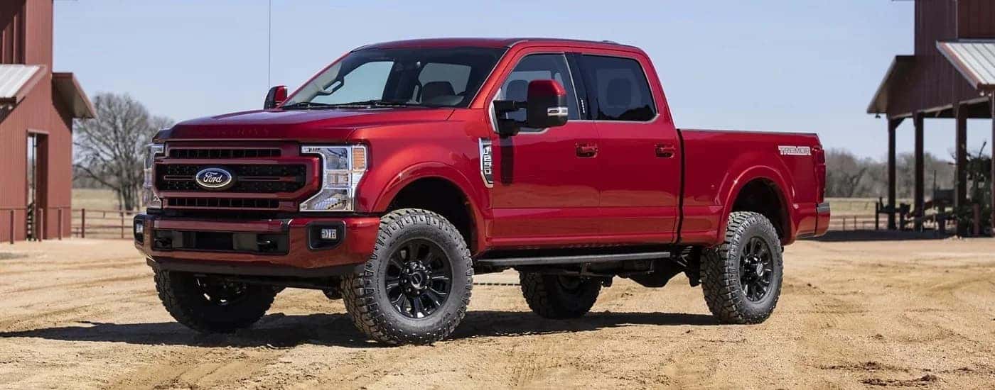 A red 2022 Ford F-250 Lariat is shown from the side after leaving a used car dealership near Burlington.