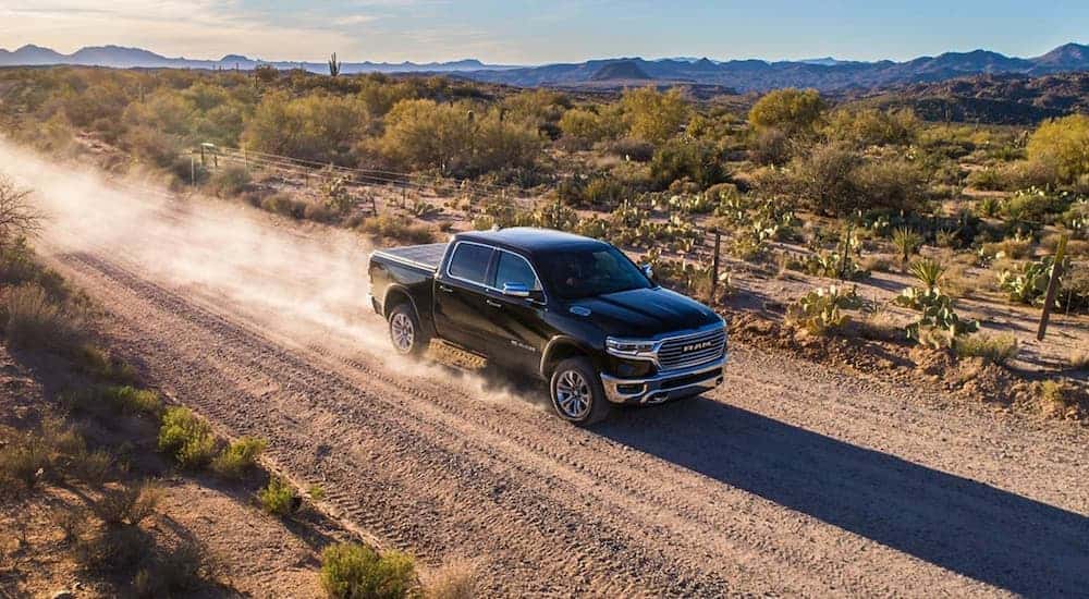 A black 2019 Ram 1500 from the side after leaving a car dealership.