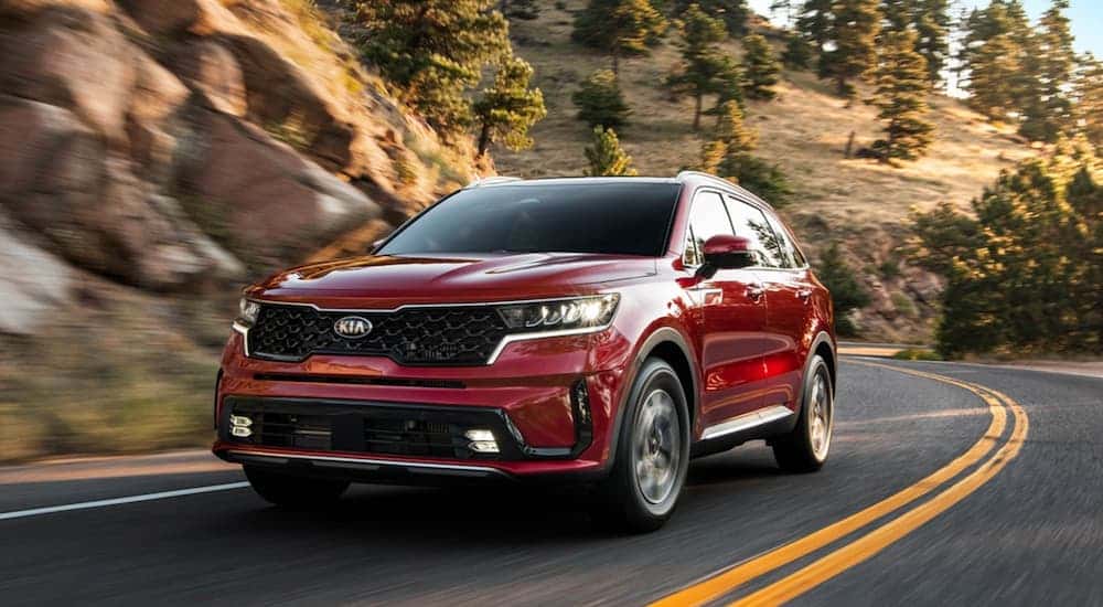 A red 2021 Kia Sorento driving on a highway.