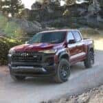 A red 2023 Chevy Colorado off-roading on a dirt road