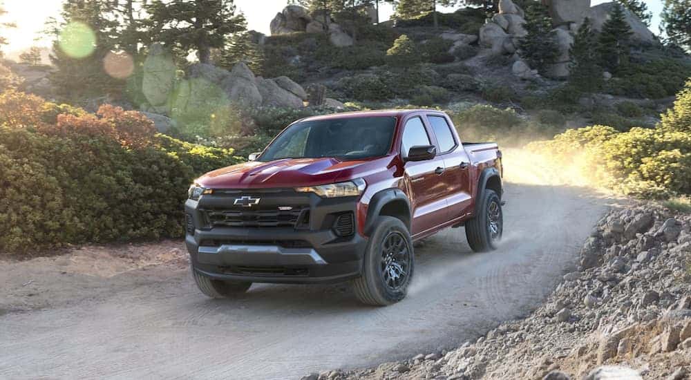 A red 2023 Chevy Colorado off-roading on a dirt road