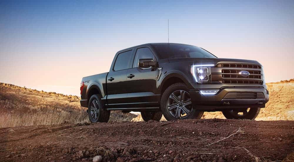 A black 2022 Ford F-150 from the side while parked off-road.