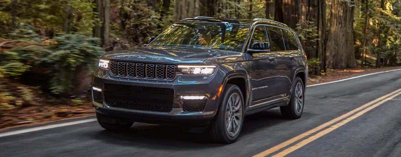 A gray 2021 Jeep Grand Cherokee L driving down a rural road