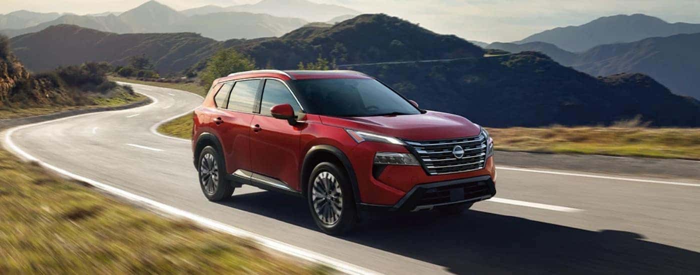 A red 2024 Nissan Rogue from the front at an angle.