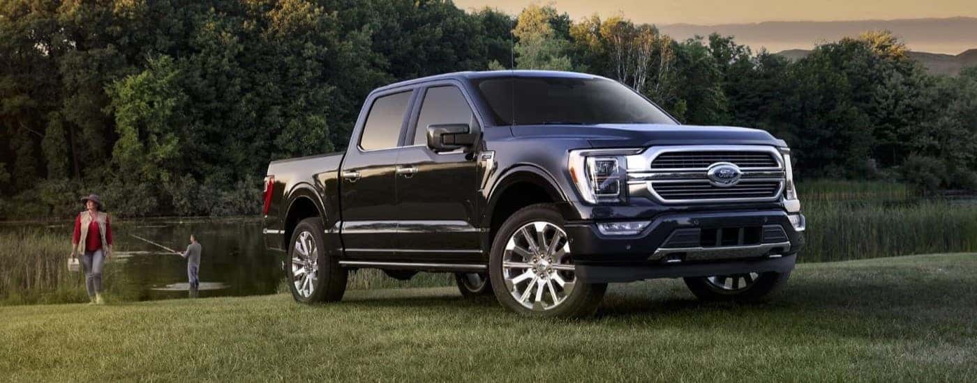 A dark blue used 2023 Ford F-150 parked near people fishing