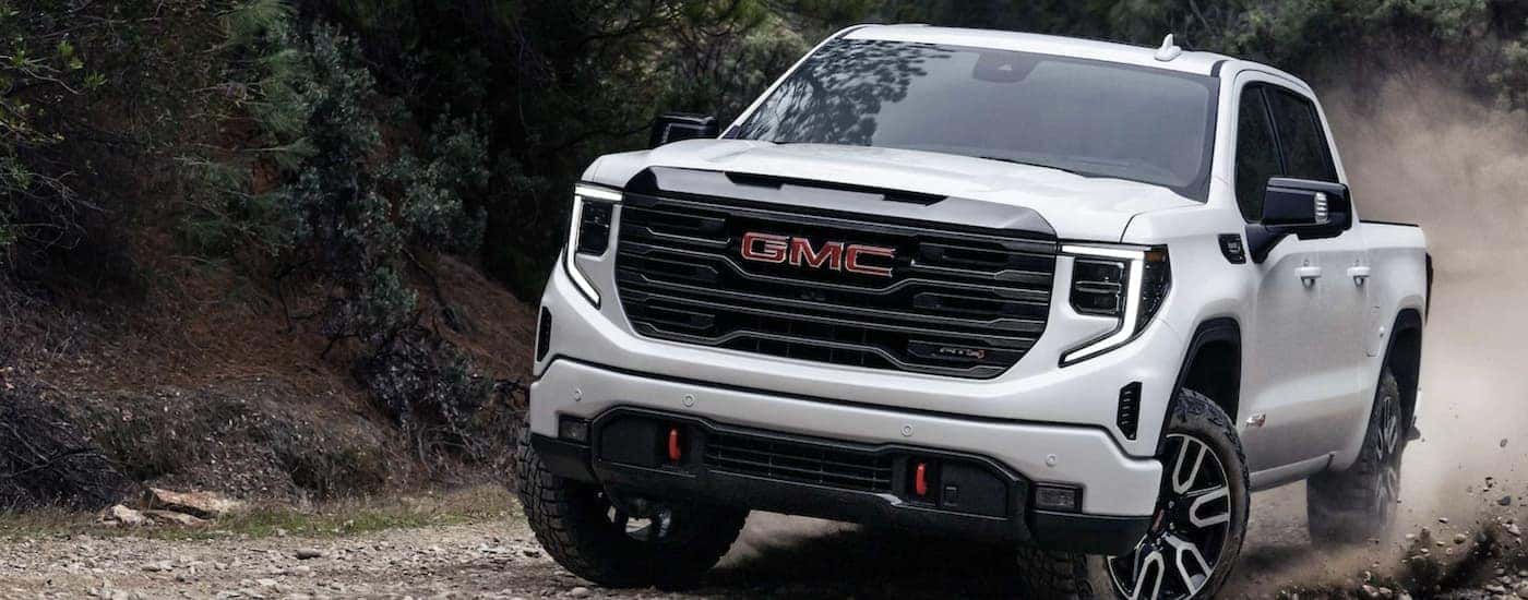 A white used 2023 GMC Sierra 1500 AT4 off-roading