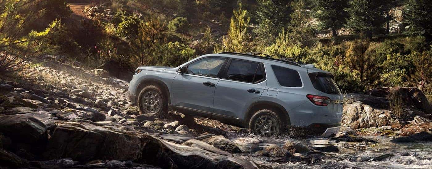Gray used 2023 Honda Pilot TrailSport driving to a used car dealership near Caldwell