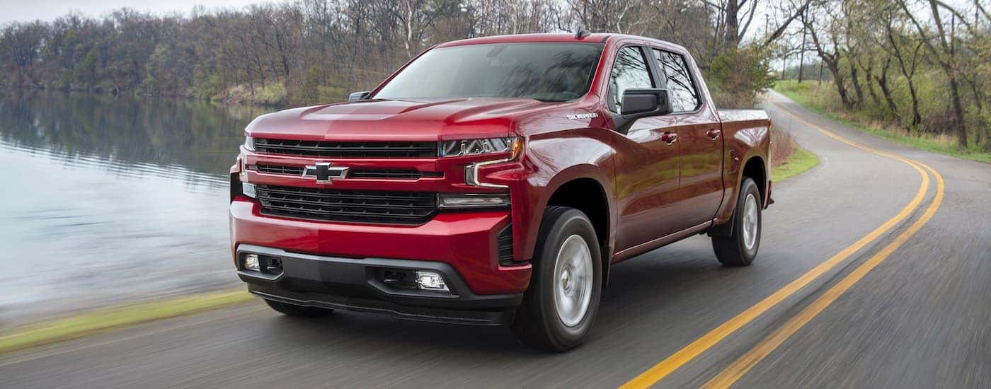 A red 2019 Chevy Silverado RST is shown from a high angle driving down a winding road.