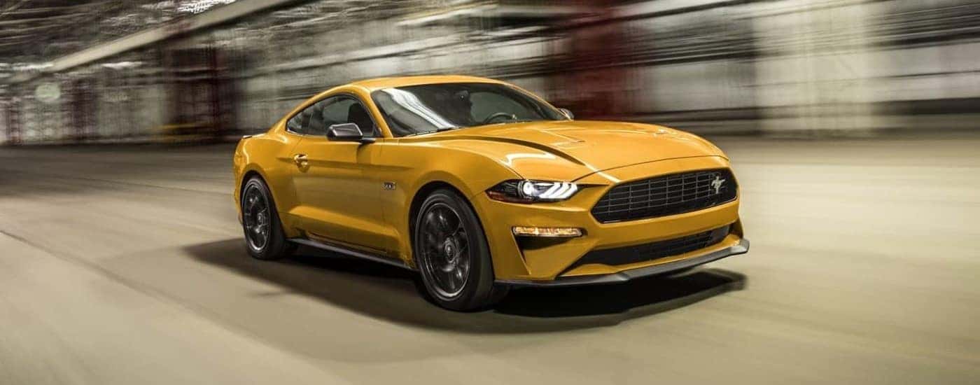 An orange 2021 Ford Mustang Ecoboost HPP is shown from the front at an angle after leaving a used Ford dealer