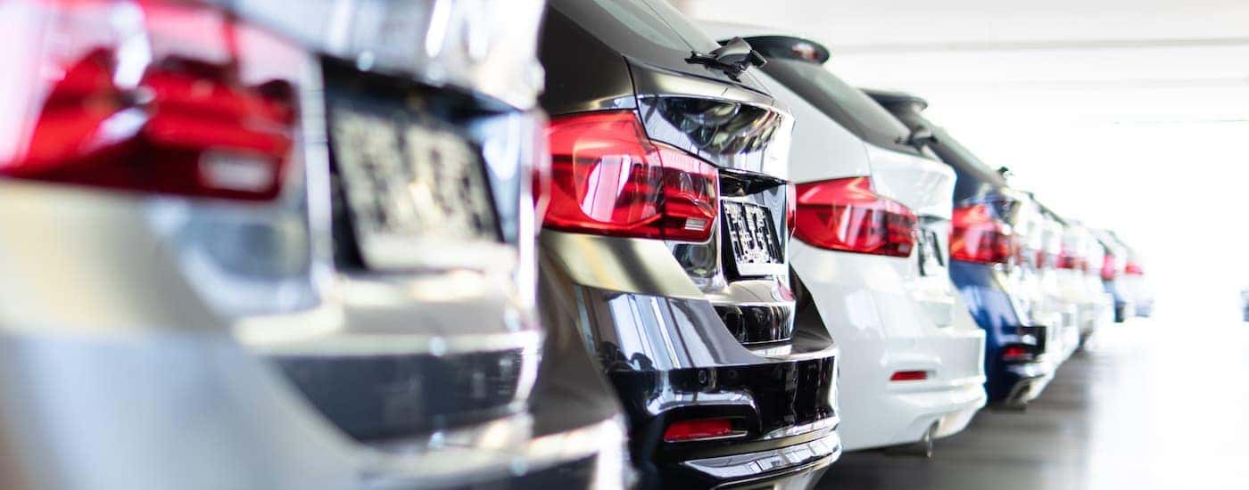 A row of used cars parked side by side in a dealership