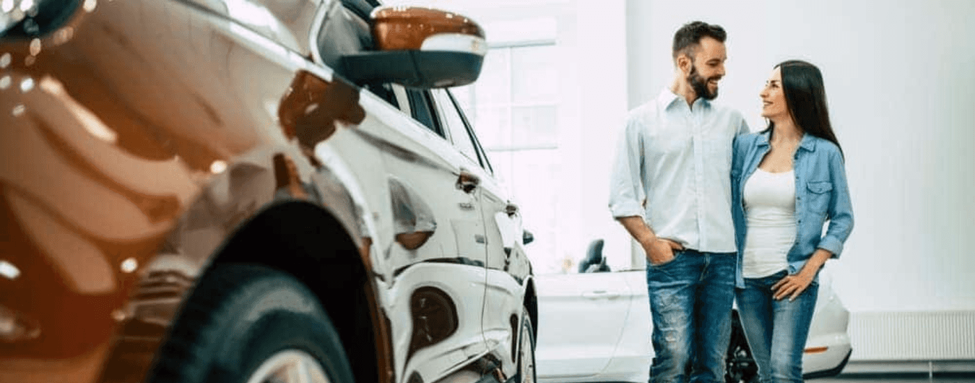A couple is shown at a certified pre-owned vehicle dealer.