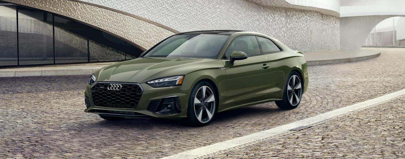 A green 2020 Audi A5 parked outside a dealer with used cars for sale near Wake Forest.