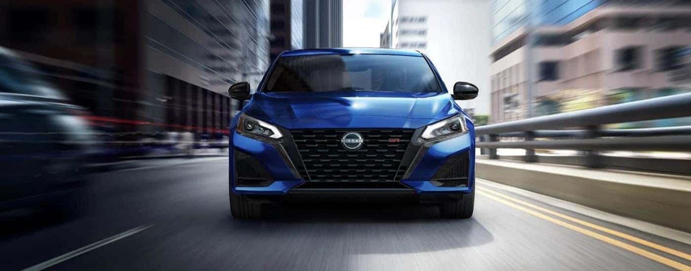 A blue 2023 Nissan Sentra SR is shown driving after viewing used cars for sale in Hillsborough.