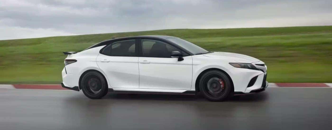 A white 2023 Toyota Camry TRD driving on a racetrack