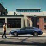 A blue 2024 Toyota Camry parked in a city.