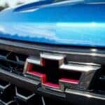 Red and chrome Chevrolet bowtie on a blue 2022 Chevy Silverado 1500