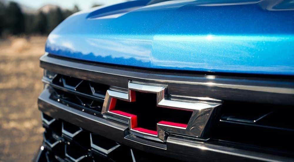 Red and chrome Chevrolet bowtie on a blue 2022 Chevy Silverado 1500